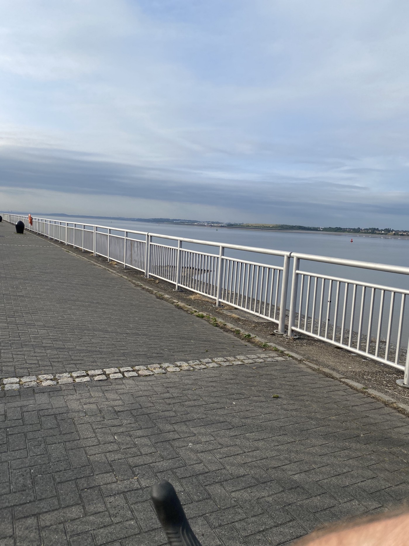 View of the River Mersey in Liverpool from the cyclepath, with some railings in between